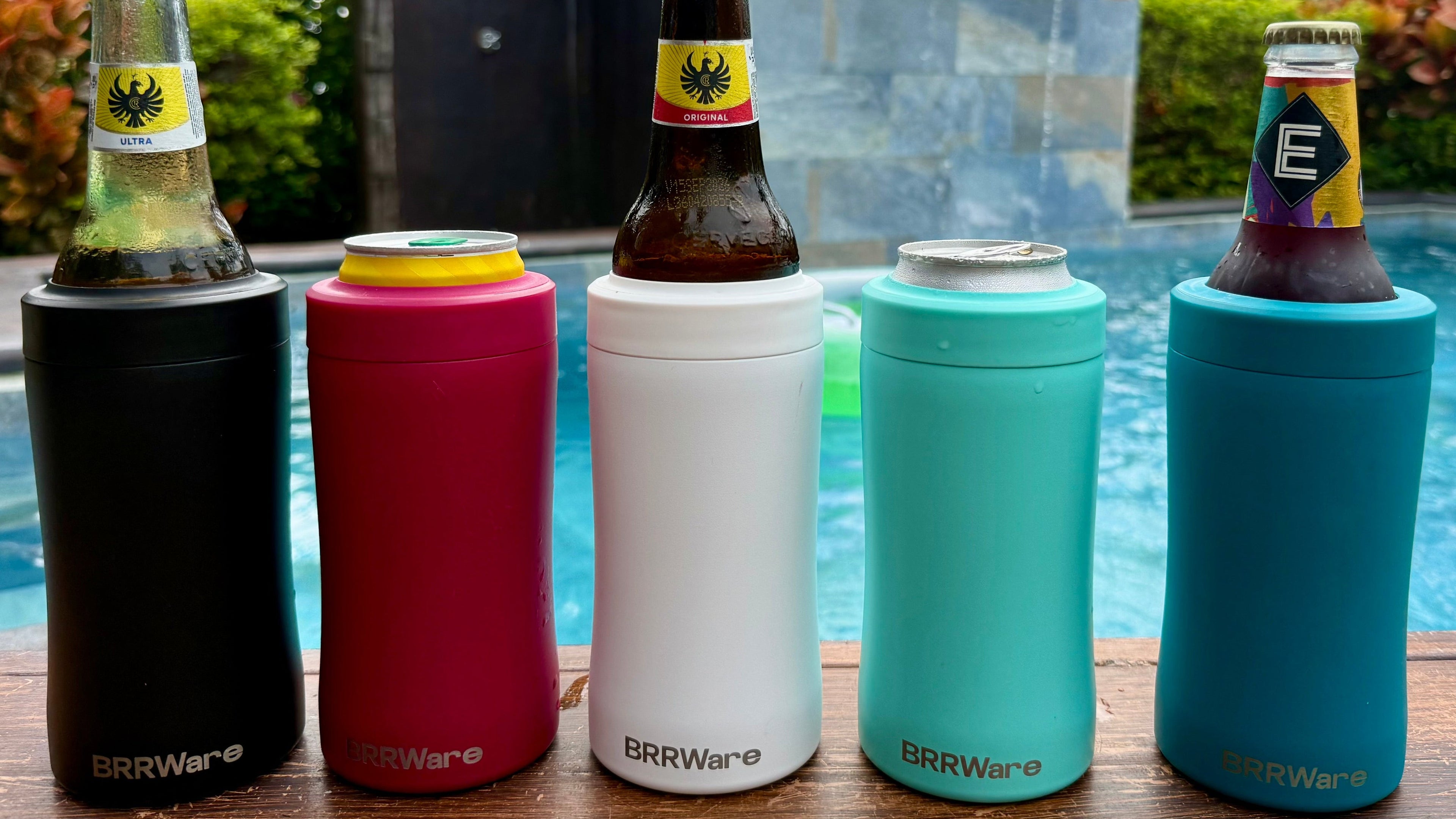 Five colorful can coolers with bottles against a poolside background